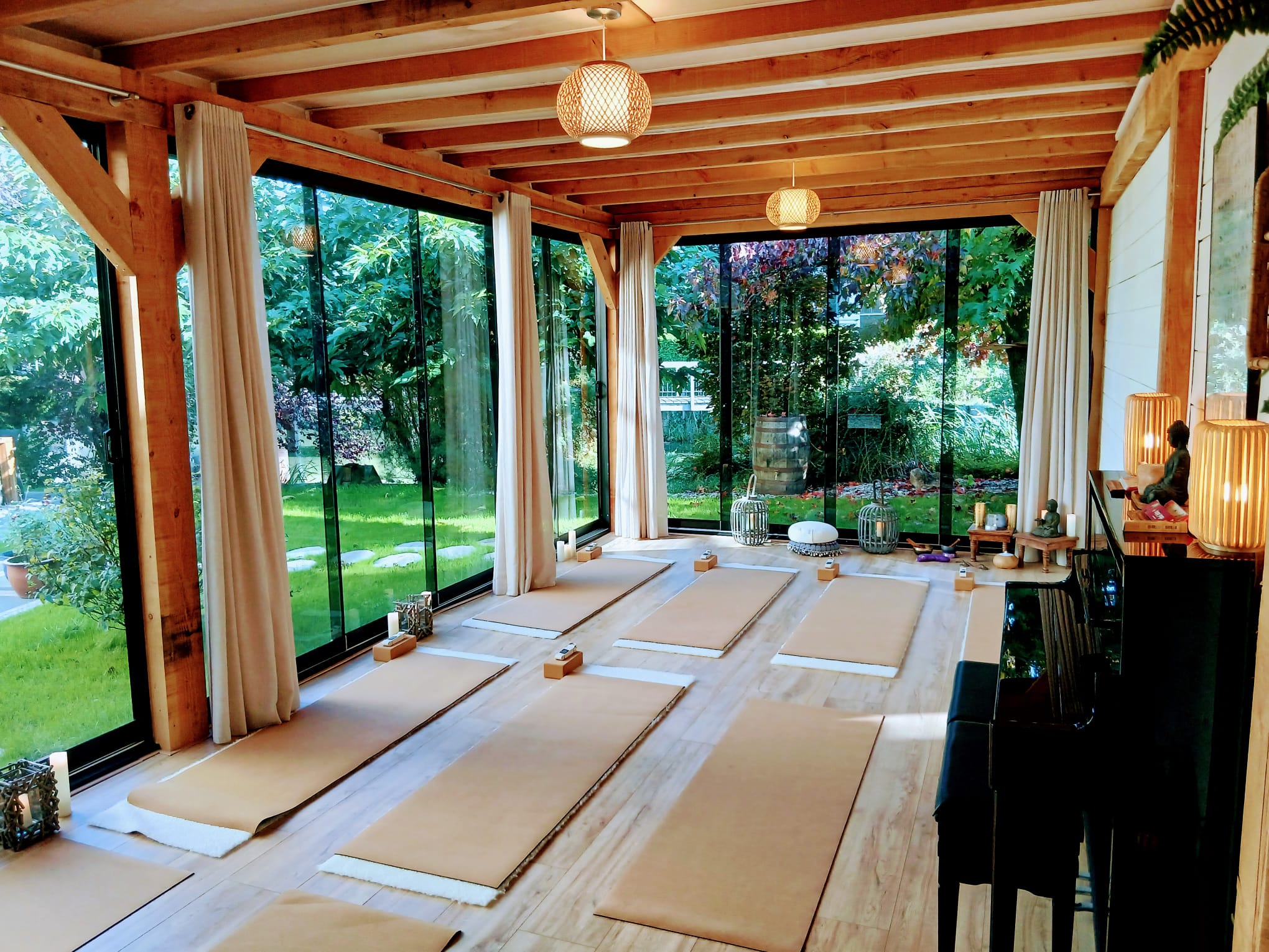 Pilates in de studio van SensZenjoy: yogamatten onder houten balken, met uitzicht op de tuin